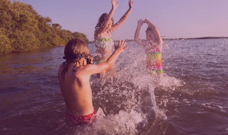 Three kids splashing in the lake